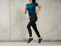 Une femme en t-shirt bleu et leggings noirs en train de courir.
