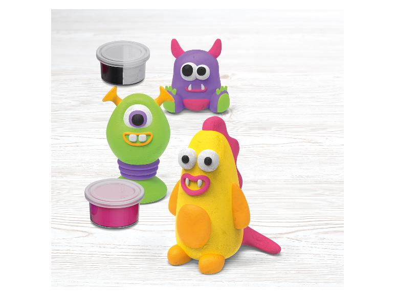 Drôles de monstres en pâte à modeler et pots de peinture.