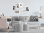 Un canapé blanc avec des coussins et un collage de photos avec l'inscription 'LIVE LAUGH LOVE' dans un salon moderne.