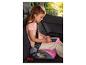 Fille dans un rehausseur de voiture dessinant sur une tablette numérique rose.