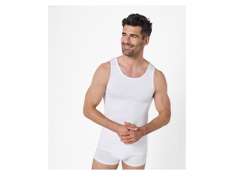 Homme souriant en débardeur blanc et caleçon