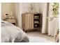 Chambre à coucher avec une armoire en bois et des accessoires clairs.