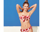 Une femme portant un bikini rouge à fleurs sur un fond bleu.