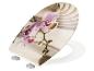 Abattant de toilettes avec motif orchidée violette et fond de sable zen.