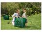 Une femme et un garçon remplissent des sacs poubelles verts de déchets de jardin.