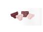 Trois paires de culottes pour filles dans des tons rose et bordeaux.