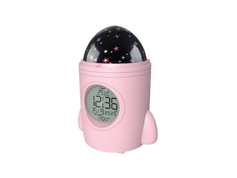 Réveil rose en forme de fusée avec projecteur d'étoiles, affichant l'heure, la date et la température.