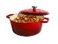 Cocotte en fonte rouge remplie d'un plat de légumes coloré, avec le couvercle entrouvert.