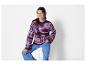 Une femme porte un pull rayé à col rond et un jean bleu.