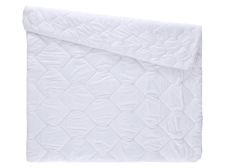 Couette blanche matelassée avec motif losanges, partiellement pliée