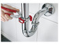 Une main utilise une pince rouge pour serrer un tuyau d'évacuation chromé.