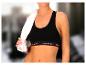 Une femme portant un soutien-gorge de sport noir Reebok et une serviette blanche.