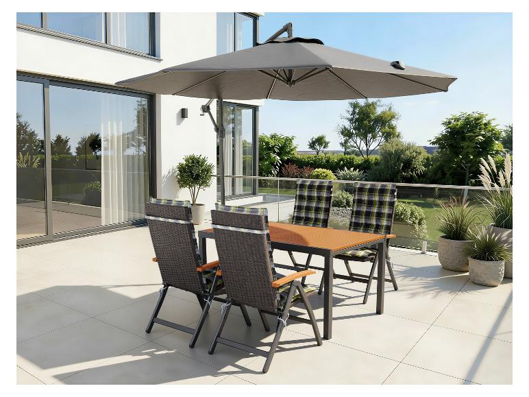 Mobilier de jardin avec table à manger, chaises et parasol sur une terrasse.