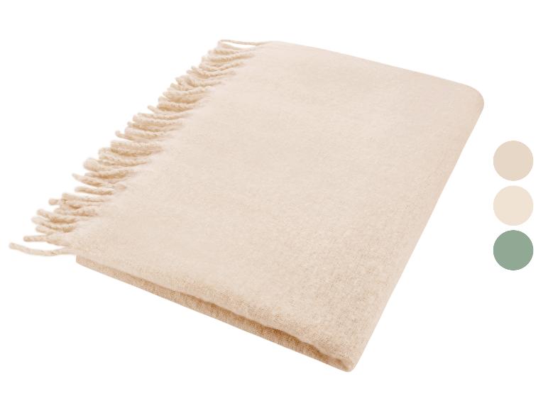 Plaid beige plié avec franges, avec échantillons de couleurs beige, crème et vert.