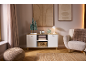 Salon chaleureux avec un buffet blanc, un fauteuil et des décorations de fête.