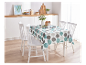 Une table de cuisine blanche avec une nappe à pois ronds et des chaises blanches.