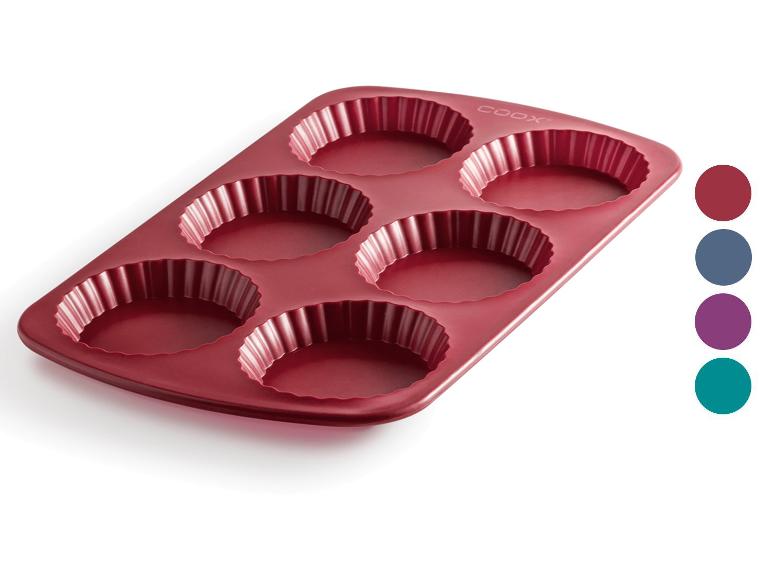 Un moule à pâtisserie en silicone rouge pour 6 tartes ou quiches individuelles.