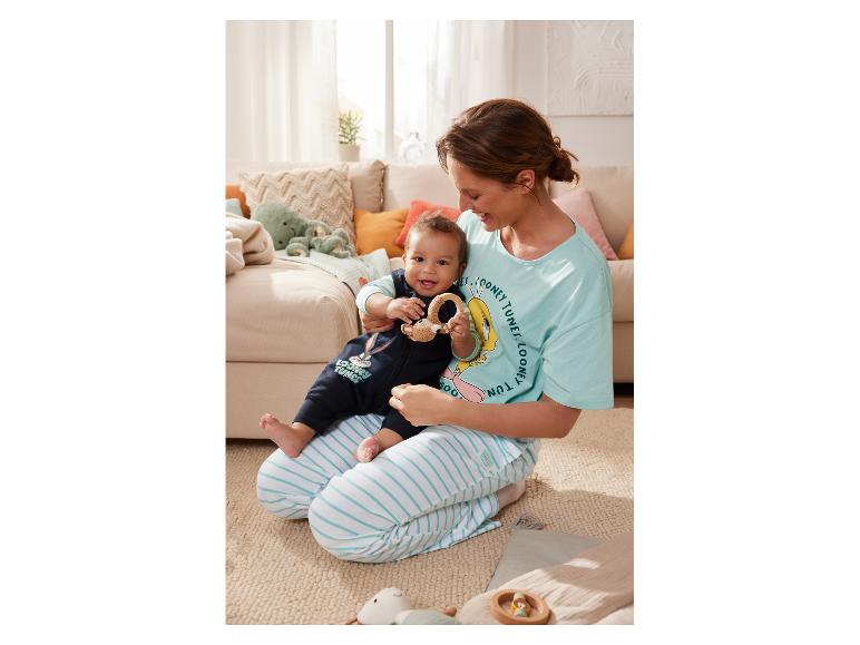 Une maman en pyjama Looney Tunes joue avec son bébé.