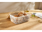 Boîte à pain en maille blanche avec couvercle en bois, remplie de différents petits pains.