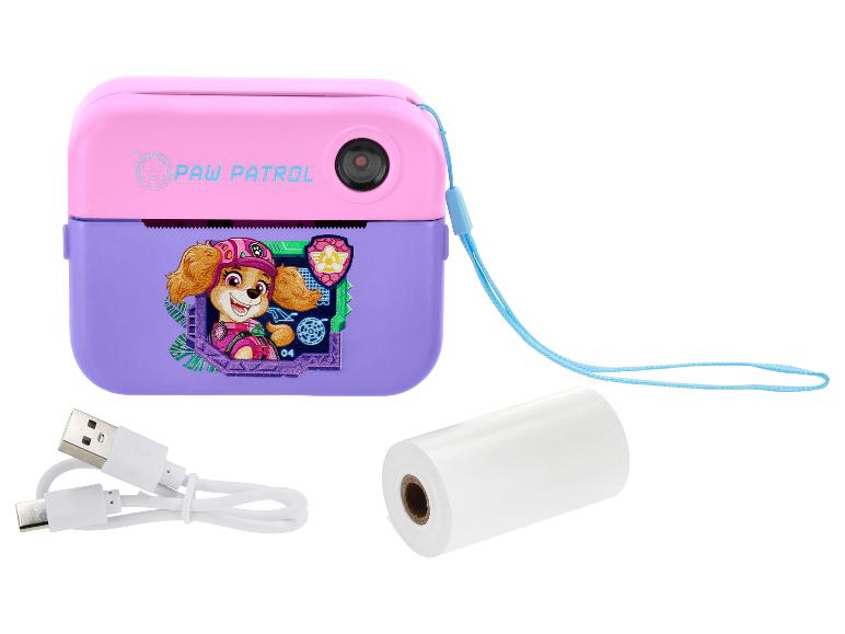 Appareil photo instantané rose et violet avec motif de personnage, câble de charge et rouleau de papier.