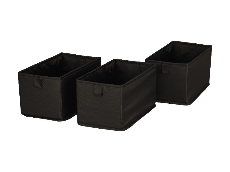 Trois boîtes de rangement en tissu noir sur fond blanc.