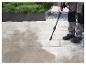 Une personne nettoie un pavé avec un nettoyeur haute pression Parkside.