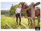 Femme en pantalon slim ESMARA® debout près d'une barrière avec un cheval. [image générée par l'IA]