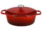 Cocotte en fonte rouge avec couvercle et bouton argenté, isolée sur fond blanc.