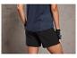 Une femme portant un haut de sport bleu marine et un short noir.
