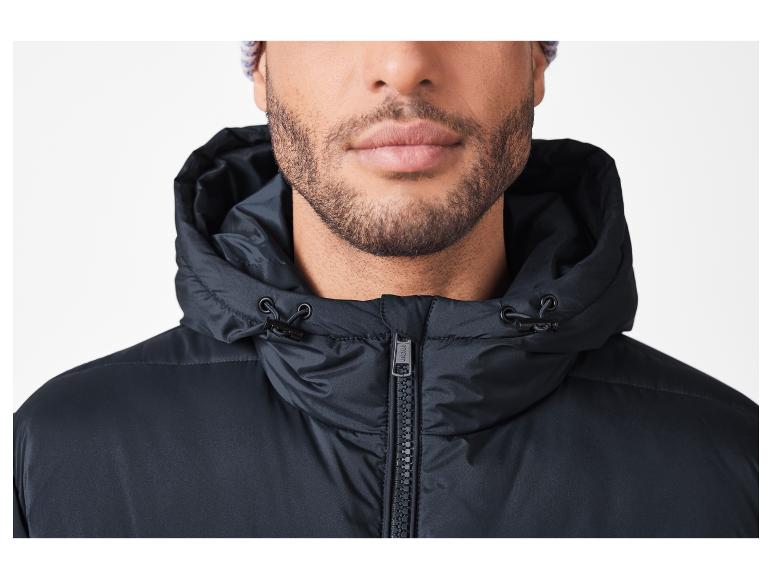 Homme barbu portant une veste noire à capuche et un bonnet tricoté.