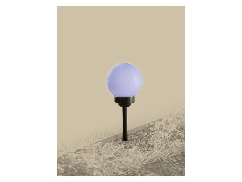 Lampe de jardin solaire avec globe violet, éclairant un parterre.