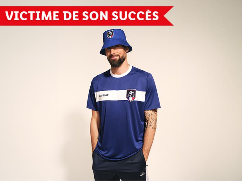 Homme en t-shirt de sport bleu et bob, avec le texte « VICTIME DE SON SUCCÈS ».