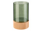 Un vase en verre vert sur un socle en bois.