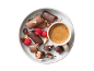 Bonbons au chocolat avec noix et framboises, avec une tasse de café.