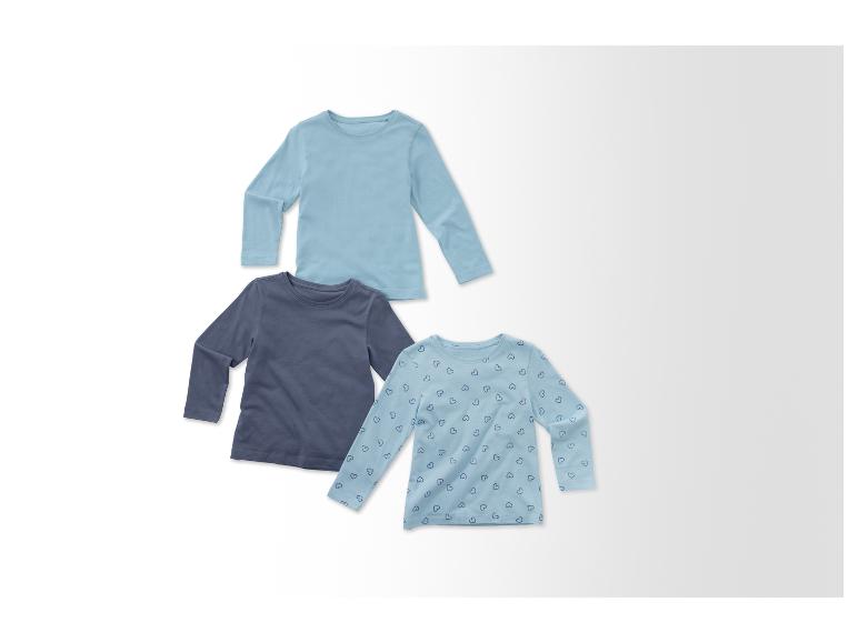 Trois t-shirts manches longues pour bébé dans des tons bleus.