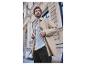 Un homme dans un manteau beige, une chemise à rayures et un jean bleu.