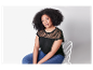 Modèle portant un t-shirt noir en dentelle et un jean.