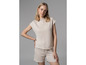 Une femme porte un haut et un short beige.