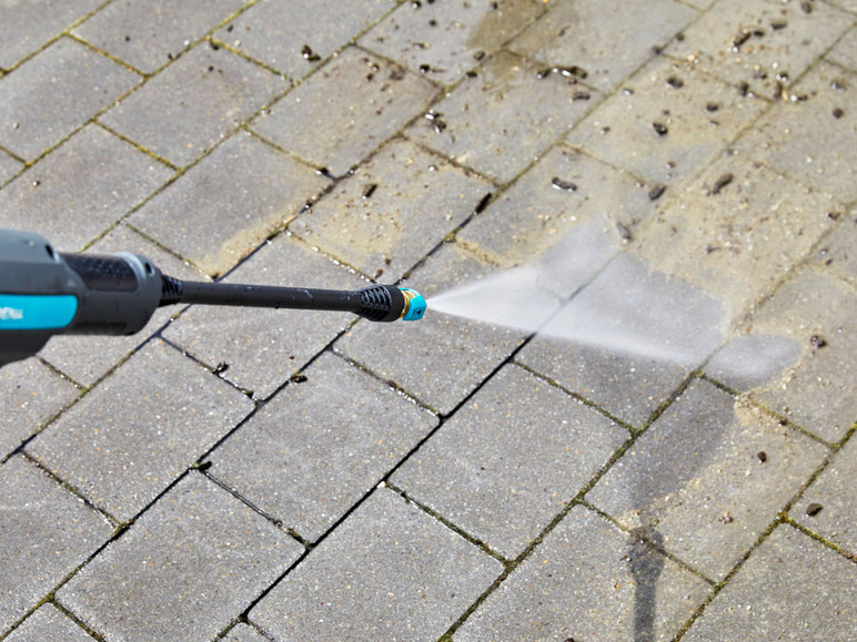 Un nettoyeur haute pression nettoie une terrasse en béton.