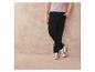 Pantalon en velours côtelé noir et baskets blanches avec des accents verts.