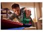 Homme utilisant une agrafeuse sans fil PARKSIDE® 4V PAT 4 D6 pour fixer du tissu rouge.
