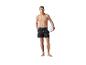 Homme en maillot de bain noir tenant un ballon de volley.