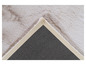 Détail d'un tapis en fourrure blanc et brun avec une bordure beige.