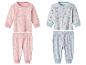 Deux ensembles de pyjamas pour bébé: rose avec flocons de neige et bleu avec lunes et étoiles.