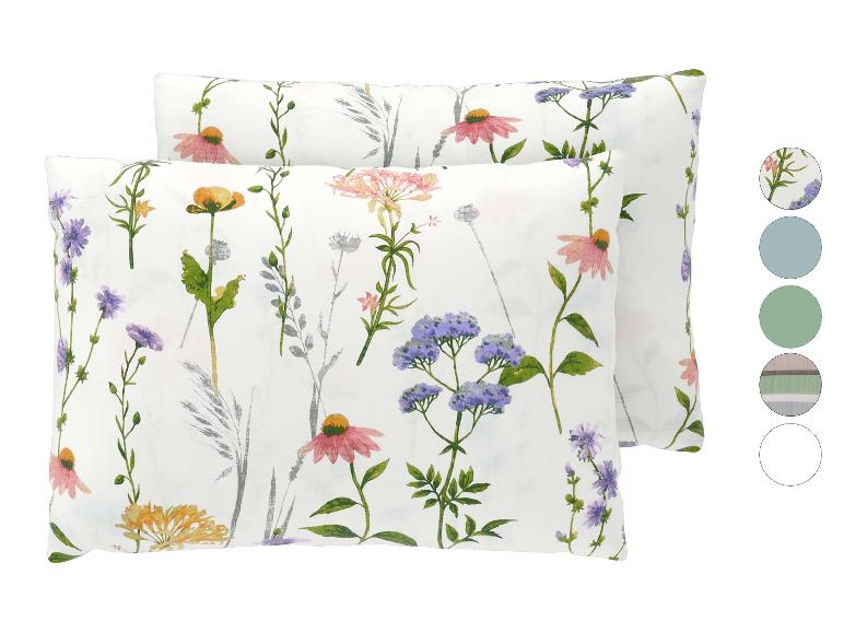 Deux oreillers blancs avec un imprimé floral de fleurs sauvages colorées.