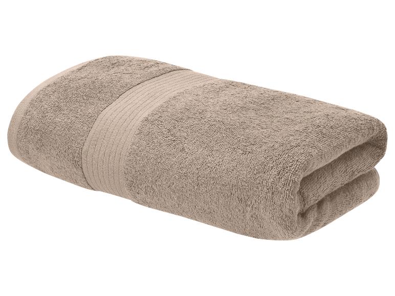 Serviette de bain beige pliée avec une bande décorative