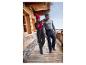 Un couple en vêtements d'hiver, dont une veste et un pantalon de ski, debout sur un balcon en bois.