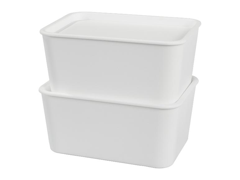 Deux boîtes de rangement blanches empilées avec couvercles, sur fond blanc.