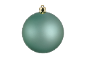 Une seule boule de Noël turquoise mate avec un capuchon doré sur fond noir.
