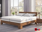 Un lit en bois avec un matelas Hüsler Nest.